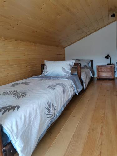 a bedroom with two beds and a wooden floor at Rudnički proplanak in Rudnik Kačerski