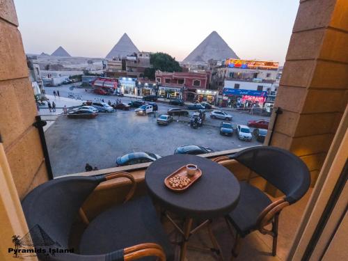 a view of the pyramids from a balcony with a table at Pyramids Island in Cairo