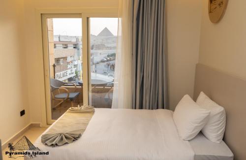 a bedroom with a bed and a window with a view at Pyramids Island in Cairo