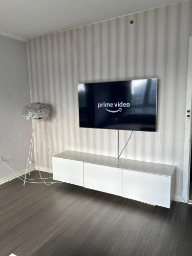 a flat screen tv sitting on top of a white entertainment center at Cozy spot, Free Netflix and Prime in Vallensbæk