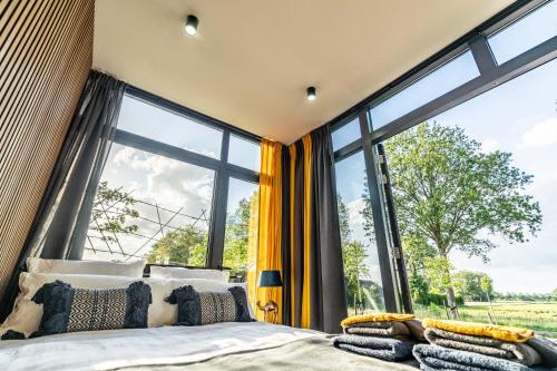 a bedroom with a bed and a large window at Tainer 'nco in Appelscha