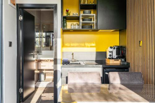 a kitchen with yellow walls and a table and chairs at Tainer 'nco in Appelscha