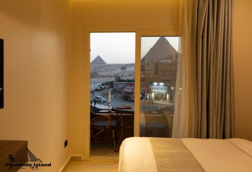 a room with a bed and a view of the pyramids at Pyramids Island in Cairo