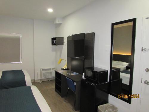 a bedroom with a bed and a desk with a mirror at Motel 6-West Des Moines, IA in West Des Moines