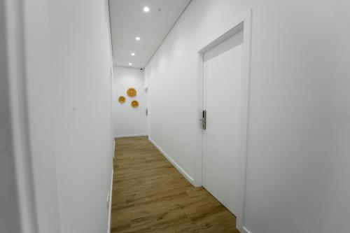 an empty hallway with white walls and a door at Ria View Guesthouse in Faro