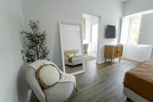 a bedroom with a mirror and a chair and a bed at Ria View Guesthouse in Faro