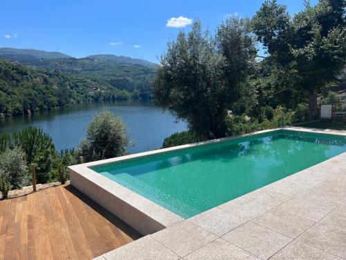 a swimming pool with a view of a river at Quinta da Ribeirinha - Douro River in Paços de Gaiolo