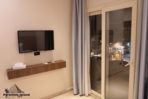 a room with a flat screen tv and a window at Pyramids Island in Cairo