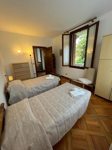 a hotel room with two beds and a window at Appartamento Villa Trento in Venice-Lido