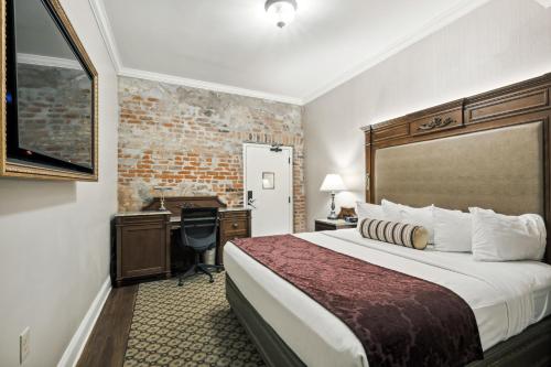a hotel room with a bed and a desk at French Market Inn in New Orleans