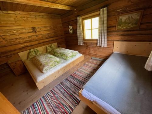 a room with two beds in a log cabin at Peintnerhof Almhütte in Innervillgraten