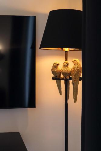 three owls sitting on a lamp in a room at The White Knight Premium Boutique Hotel in Għajnsielem
