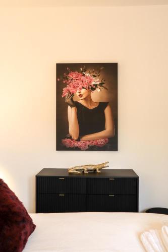 a painting of a woman with flowers on a wall at The White Knight Premium Boutique Hotel in Għajnsielem