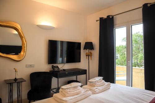 a bedroom with a bed with a television and a chair at The White Knight Premium Boutique Hotel in Għajnsielem