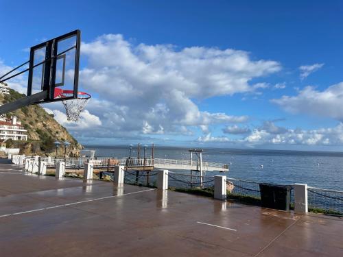 a basketball hoop on a pier next to the ocean at Oceanfront Villa With Breathtaking Views in Avalon