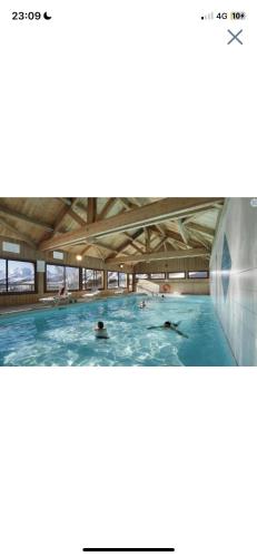 un groupe de personnes nageant dans une piscine dans l'établissement Appartement La Toussuire, à La Toussuire