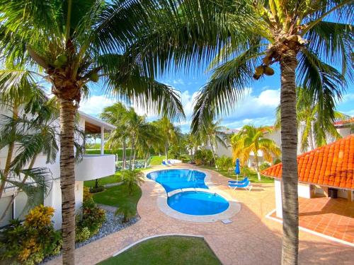 an aerial view of a resort with a swimming pool and palm trees at Villa Ángeles - Elegancia en la Zona Hotelera in Cancún