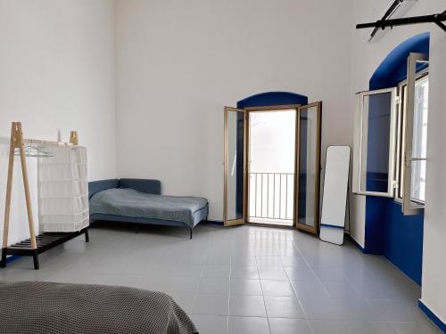 a room with a bed and a couch and a window at Casa Rara al Mare in Monopoli