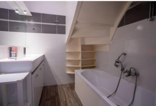 a bathroom with a sink and a bath tub at Les bois flottés in La Richardais