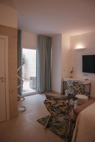 a living room with a couch and a chair and a window at The White Knight Premium Boutique Hotel in Għajnsielem