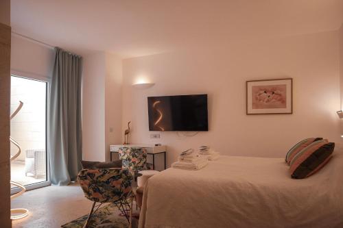 a bedroom with a bed and a tv on the wall at The White Knight Premium Boutique Hotel in Għajnsielem