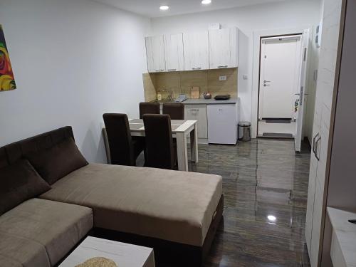 a living room with a couch and a table and a kitchen at Prenoćište SILVER LUX Srebrno Jezero in Veliko Gradište
