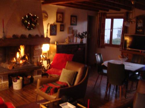 - un salon avec une cheminée, une table et des chaises dans l'établissement Maison de vacances Pyrénées, à La Llagonne