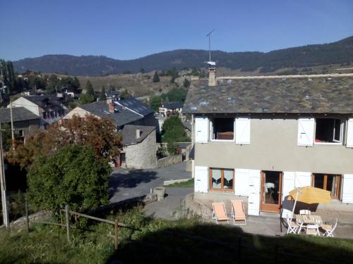 une maison blanche avec des tables et des chaises devant elle dans l'établissement Maison de vacances Pyrénées, à La Llagonne