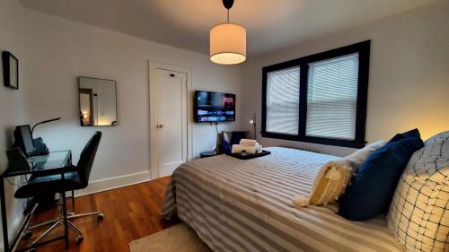 a bedroom with a bed and a desk and a window at The Blue Sapphire 2BR 2 King beds & ample backyard in Bridgeport