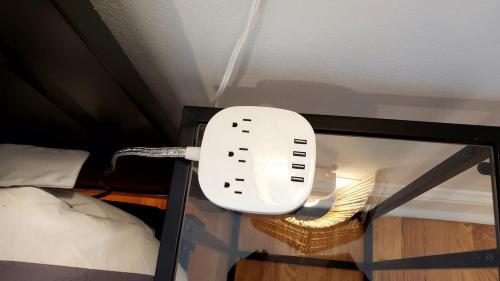 a white phone on a shelf next to a bed at The Blue Sapphire 2BR 2 King beds & ample backyard in Bridgeport