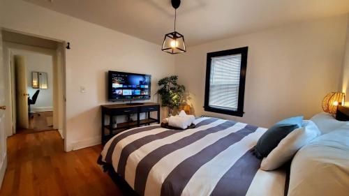 a bedroom with a large bed and a flat screen tv at The Blue Sapphire 2BR 2 King beds & ample backyard in Bridgeport