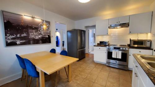 a kitchen with a table and a stainless steel refrigerator at The Blue Sapphire 2BR 2 King beds & ample backyard in Bridgeport