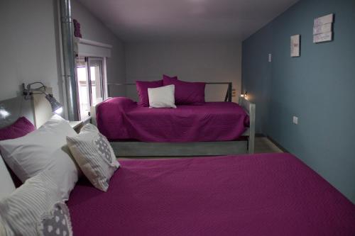 two beds in a room with purple sheets at Andanzas Bahia Uni in Bahía Blanca