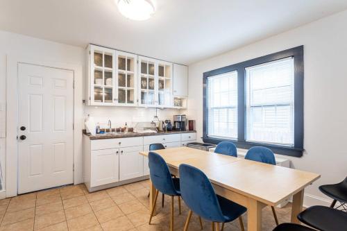 a kitchen with a wooden table and blue chairs at The Blue Sapphire 2BR 2 King beds & ample backyard in Bridgeport