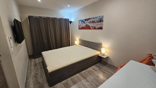 une petite chambre avec deux lits et une télévision dans l'établissement F3 dans une villa SuperCannes, à Vallauris