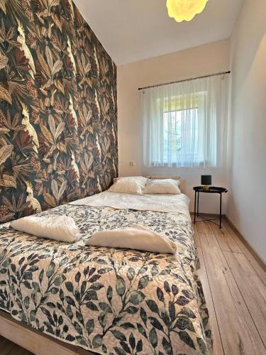 a bedroom with a large bed with a floral wallpaper at Babie Lato in Mrągowo