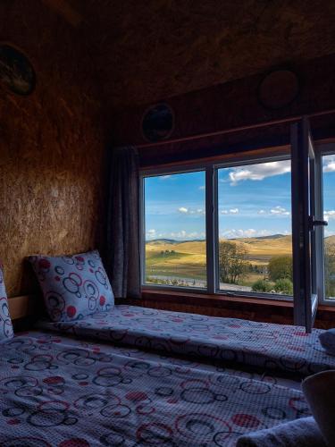 a bedroom with a bed and a large window at Domaćinstvo Krstajić - Rural holiday in Žabljak