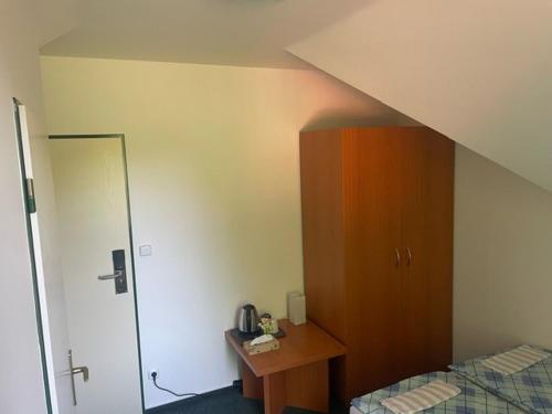 a bedroom with a bed and a wooden cabinet at Patriot penzion a kemp in Držková