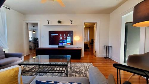 a living room with a couch and a tv at The B&W Haven 3BR private office by LI Ferry in Bridgeport