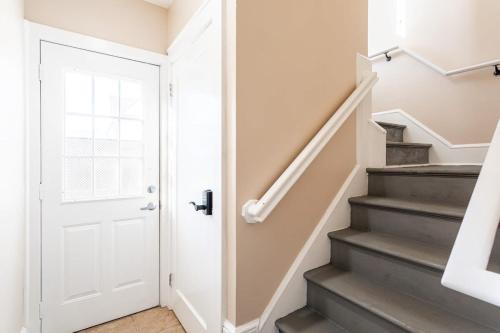 a white door in a hallway with stairs at The B&W Haven 3BR private office by LI Ferry in Bridgeport