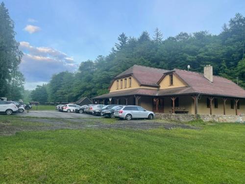 a building with a bunch of cars parked in a parking lot at Patriot penzion a kemp in Držková