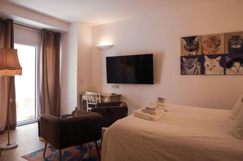 a hotel room with a bed and a flat screen tv at The White Knight Premium Boutique Hotel in Għajnsielem