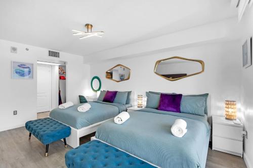 two beds in a room with blue and purple at Oceanside Penthouse Apartment in Brickell Miami, Pool, Free Parking in Miami