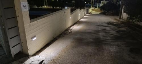 an empty street at night with a white fence at AIR-IN Rooms with magnificent views in Spáta