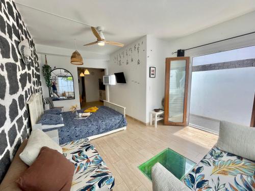 een woonkamer met een blauwe bank en een woonkamer met: bij Loft La Cueva de los Pájaros in Playa Blanca