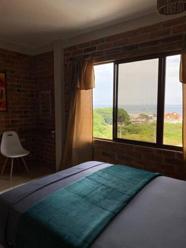a bedroom with a bed and a large window at The UFO Shore in Las Núñez