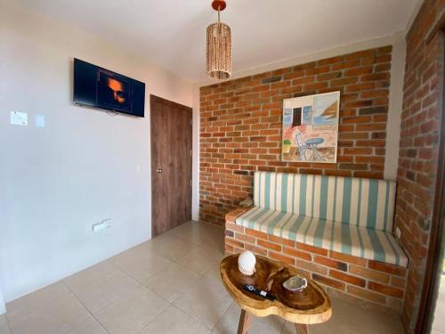a living room with a bench and a brick wall at The UFO Shore in Las Núñez