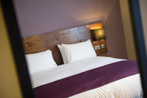 a bedroom with a large bed with white sheets and pillows at Toby Carvery Exeter M5 J30 by Innkeeper's Collection in Exeter
