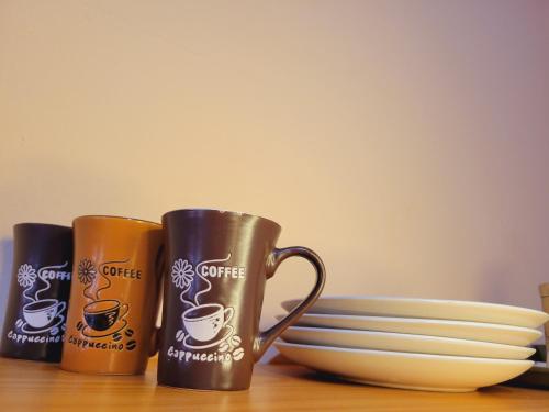 two coffee mugs sitting on a table next to a plate at Casa & Alojamiento La Roca in Puerto Cortes