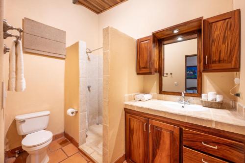a bathroom with a toilet and a sink and a shower at BP Surf Hotel in Playa Grande